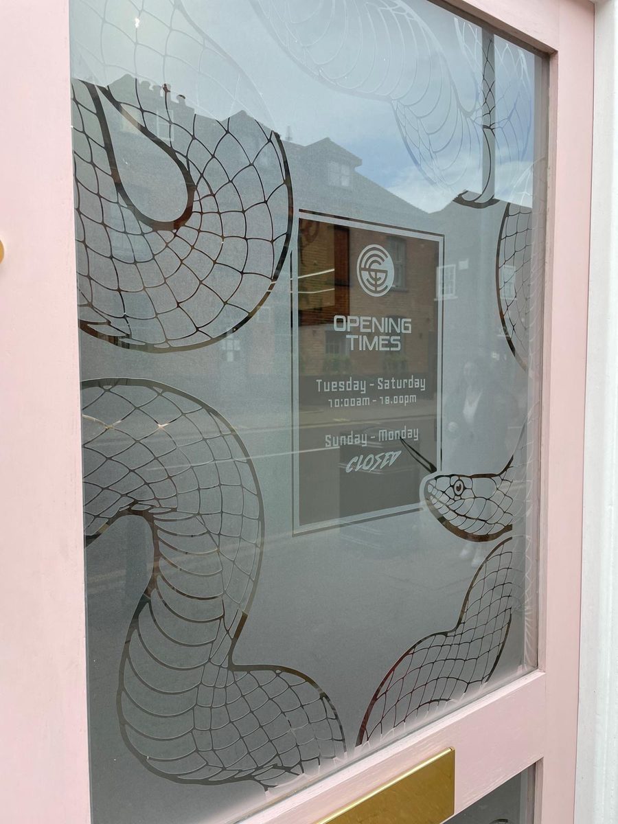 Etched snake window graphic with opening times by Lauryn Jaime Ltd
